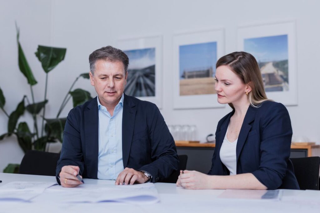 Zwei Projektverantwortliche bei der Planung am Tisch – Symbolbild für strukturierte Projektsteuerung