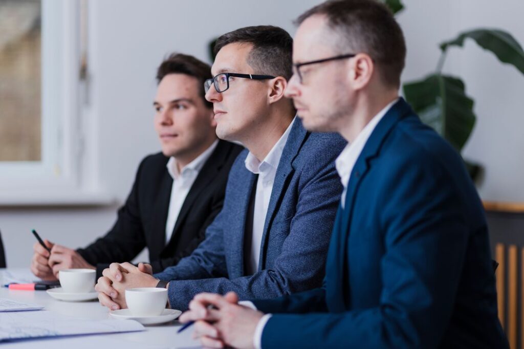 Drei Mitarbeitende bei einer Besprechung – Symbolbild für Kontaktaufnahme und professionelle Beratung