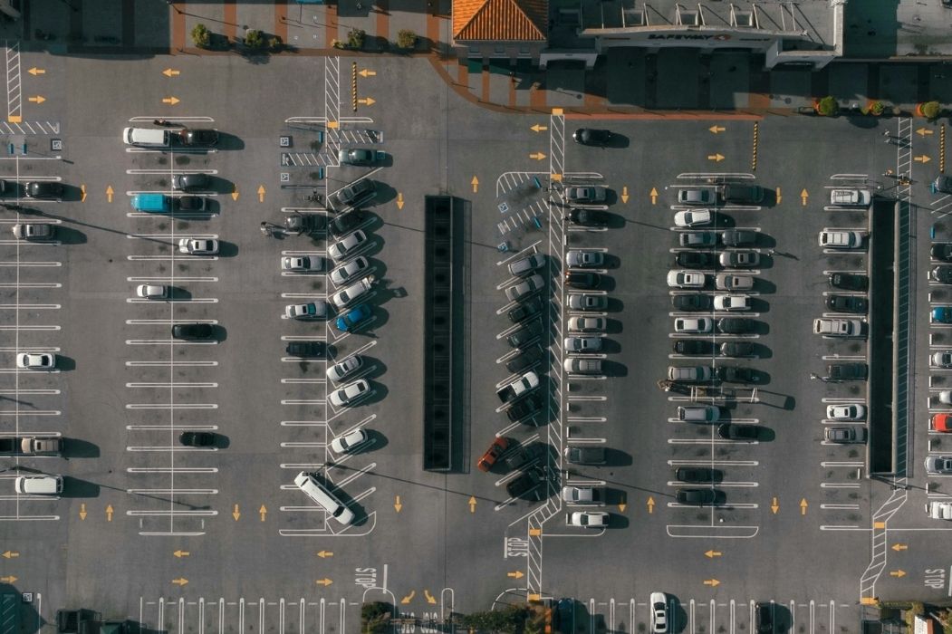 Luftbild eines stark genutzten Parkplatzes mit PKWs und Zufahrten bei der Muthgasse