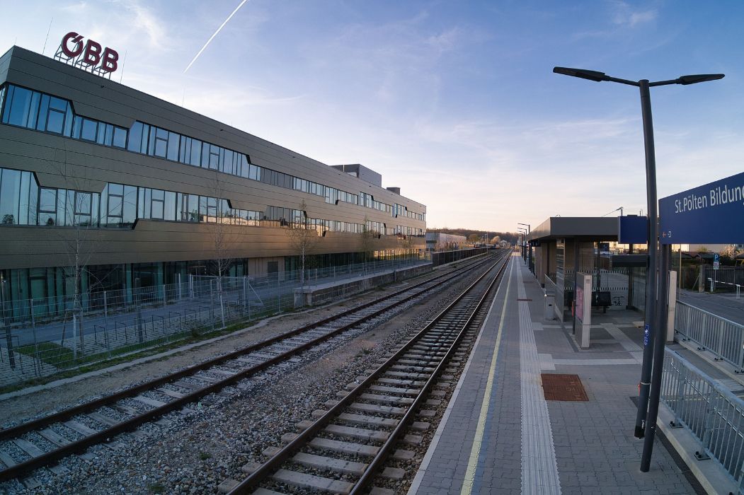 Moderner Bahnsteig mit Beschilderung und Gleisanlagen bei der Haltestelle St. Pölten Bildungscampus